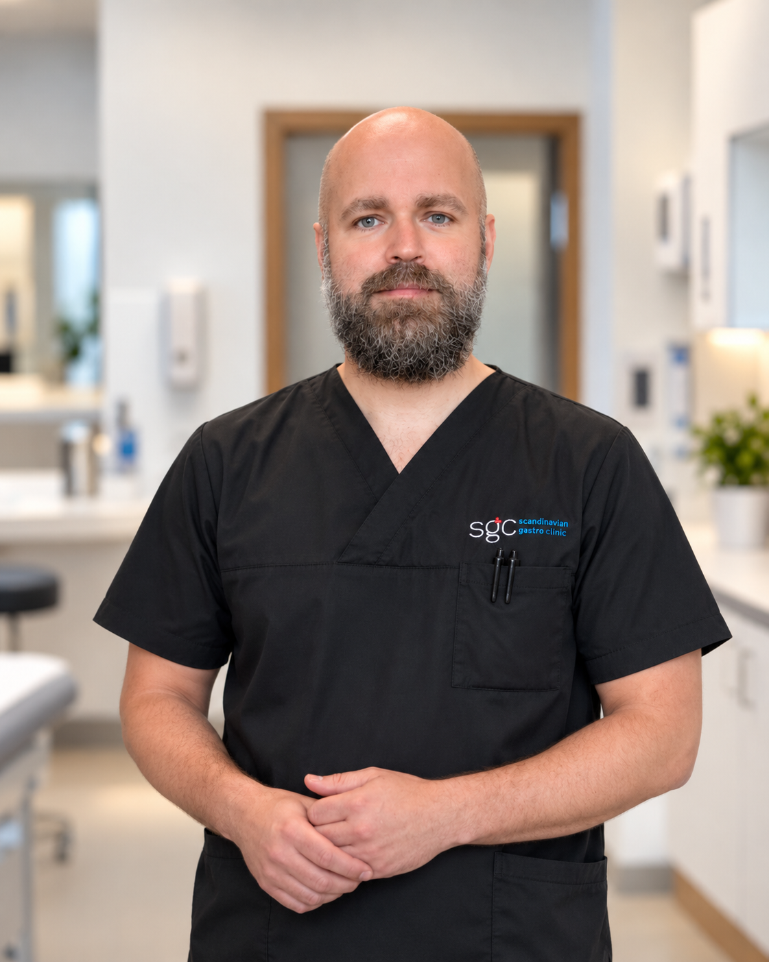 Porträtt av en skäggig man i klinikens arbetskläder